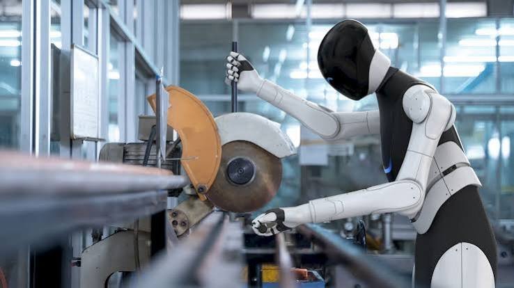 Humanoid robot operating next to an industrial production line.